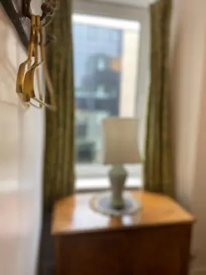 a lamp on a table in front of a window at 1 Bed Flat Near Edinburgh Castle in Edinburgh