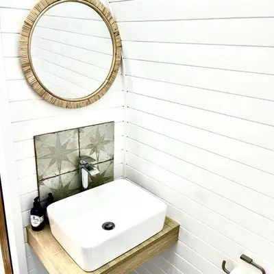 a bathroom with a white sink and a mirror at Heather Pod in Perth