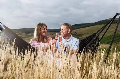 a man and woman looking at a cell phone in a field at Heather Pod in Perth