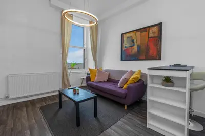 a living room with a purple couch and a table at Free Parking - City Centre - Stunning Views - Great Location in Edinburgh