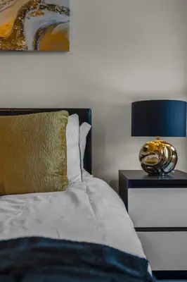 a bedroom with a bed and a lamp on a nightstand at Free Parking - City Centre - Stunning Views - Great Location in Edinburgh