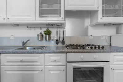 a white kitchen with white cabinets and a sink at Free Parking - City Centre - Stunning Views - Great Location in Edinburgh