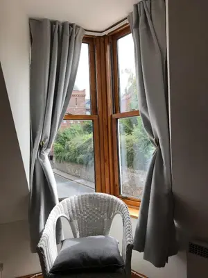 a chair sitting in front of a window at STYLISH APARTMENT with PRIVATE ROOF TERRACE in Edinburgh