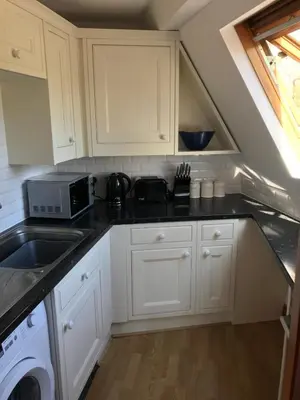 a kitchen with white cabinets and a sink and a microwave at STYLISH APARTMENT with PRIVATE ROOF TERRACE in Edinburgh