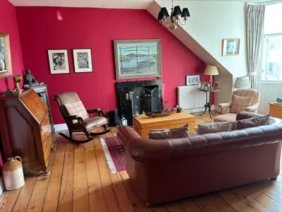 a living room with a couch and a red wall at Stunning 2-Bedroom Georgian Flat, City Centre in Edinburgh
