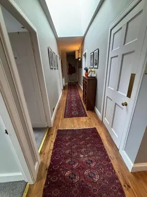 a hallway with a red rug and a door at Stunning 2-Bedroom Georgian Flat, City Centre in Edinburgh