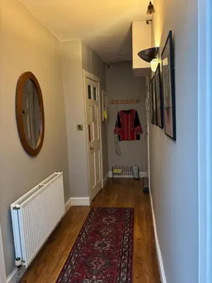 a hallway with a rug and a mirror on a wall at Stunning 2-Bedroom Georgian Flat, City Centre in Edinburgh