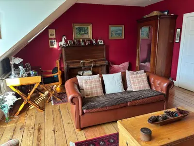 a living room with a leather couch and a piano at Stunning 2-Bedroom Georgian Flat, City Centre in Edinburgh