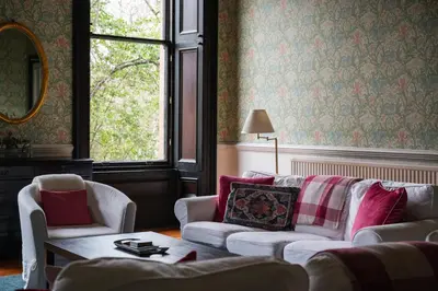 a living room with two white couches and a window at 7 Crown Gardens Glasgow in Glasgow