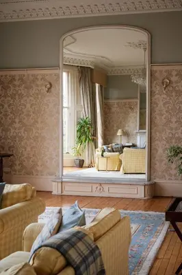 a living room with a large mirror and a couch at 7 Crown Gardens Glasgow in Glasgow