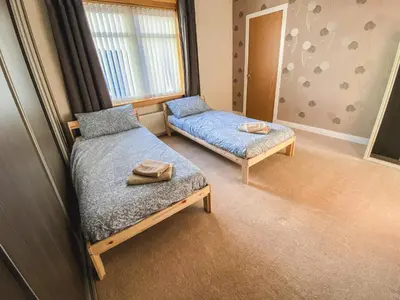 a bedroom with a bed and a couch and a window at 20min to Edinburgh City Centre Scotland Gateway in Cowdenbeath