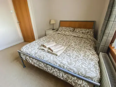 a bedroom with a bed with two towels on it at 20min to Edinburgh City Centre Scotland Gateway in Cowdenbeath