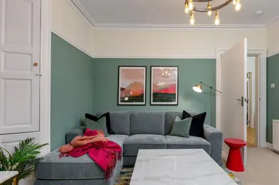a living room with a couch and a table at Charming and Cosy Getaway in Cambusbarron
