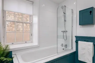 a bathroom with a bath tub and a window at Charming and Cosy Getaway in Cambusbarron