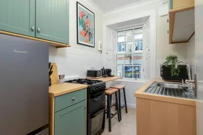 a kitchen with a stove and a sink at Charming and Cosy Getaway in Cambusbarron
