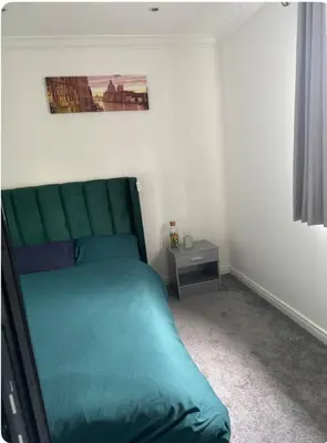 a bedroom with a green bed and a night stand at The City Glasgow in Glasgow