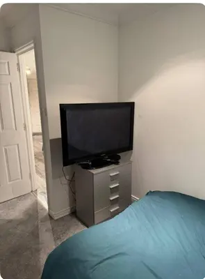 a bedroom with a flat screen tv and a bed at The City Glasgow in Glasgow