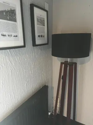 a lamp in a room with two pictures on the wall at The Bee Hive Hotel in Coylton