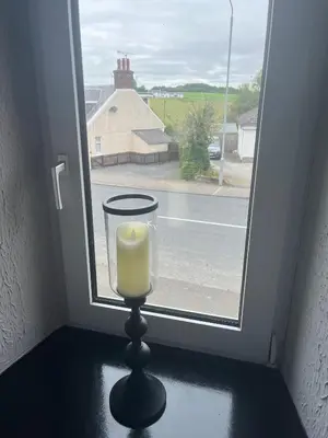 a candle on a table in front of a window at The Bee Hive Hotel in Coylton