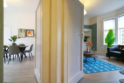 a hallway with a living room and a dining room at Signature - St James House in Abbotsinch