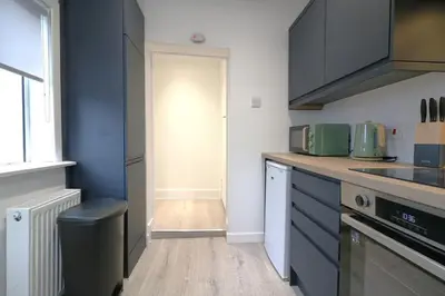 a kitchen with blue cabinets and a counter top at Signature - St James House in Abbotsinch