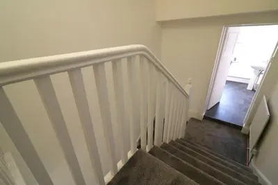 a staircase with white railings and a stair case at Signature - St James House in Abbotsinch