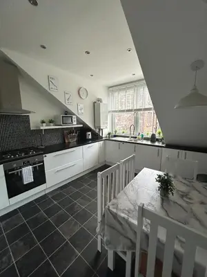a kitchen with a table and a table and a table and chairs at The Bay View Apartment in Gourock