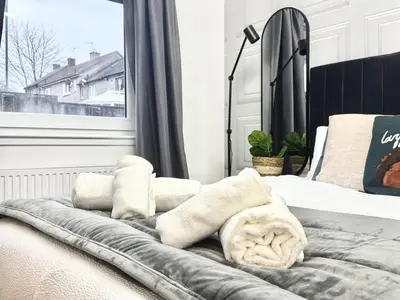 a bedroom with a bed with towels on it at Summerlee Gateaway in Coatbridge