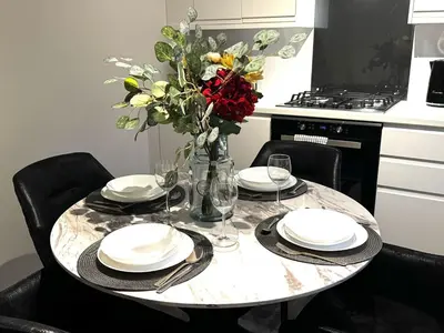a dining room table with plates and a vase of flowers at Summerlee Gateaway in Coatbridge
