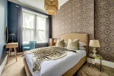 a bedroom with a zebra print bed and a window at Maya's Holiday Homes in Glasgow
