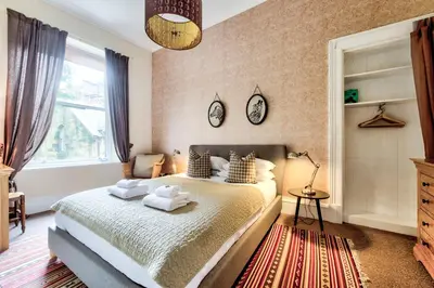 a bedroom with a bed with towels on it at Maya's Holiday Homes in Glasgow