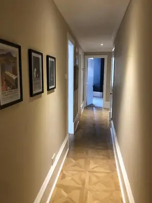 a hallway of a house with paintings on the walls at Maya's Holiday Homes in Glasgow