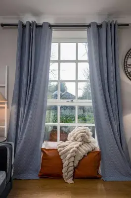 a window with blue curtains in a living room at The Mill Retreat in Stirling