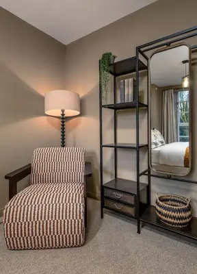 a living room with a chair and a mirror at The Mill Retreat in Stirling