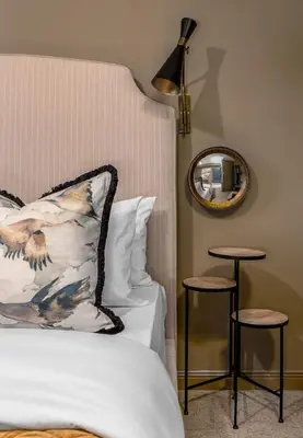 a bedroom with a bed and a mirror and stools at The Mill Retreat in Stirling