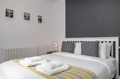 a bedroom with a bed with towels on it at Castle Esplanade Apartment in Stirling