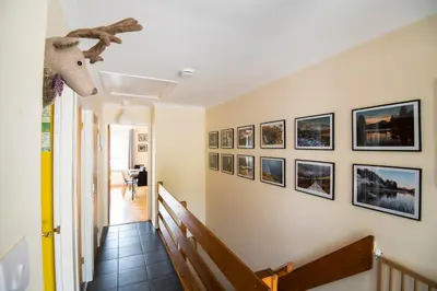 a hallway with pictures on the wall at 12 & 14 On the Hill Aberfoyle, twin holiday cottages in Scenic Loch Lomond & Trossachs National Park in Aberfoyle