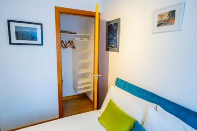 a bedroom with a bed and an open closet at 12 & 14 On the Hill Aberfoyle, twin holiday cottages in Scenic Loch Lomond & Trossachs National Park in Aberfoyle