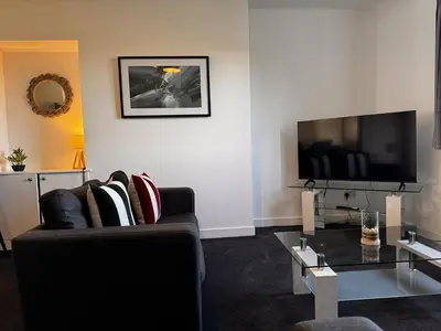 a living room with a couch and a flat screen tv at Loch Ore View in Kelty