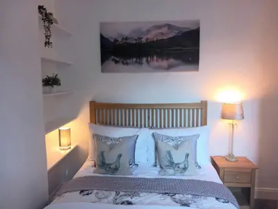 a bedroom with a bed with a picture on the wall at Lismore in Crieff