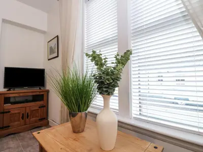 a white vase sitting on a table next to a window at Lismore in Crieff