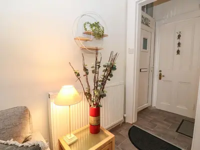 a living room with a lamp and a vase with flowers at Lismore in Crieff