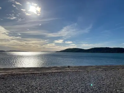 a large body of water with the sun in the sky at The Old Shed in Benderloch