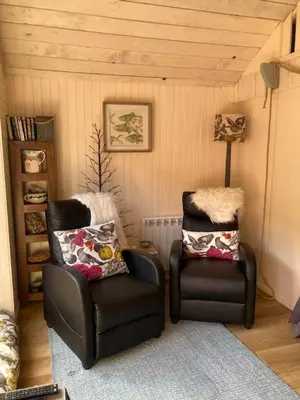 a room with two chairs and a lamp at The Old Shed in Benderloch