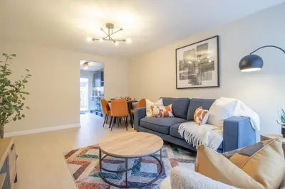 a living room with a blue couch and a table at Hawick Apartment- 2-Bed in Coatbridge, Mins from Motorway to Glasgow in Old Monkland