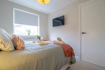 a bedroom with a bed and a window at Hawick Apartment- 2-Bed in Coatbridge, Mins from Motorway to Glasgow in Old Monkland