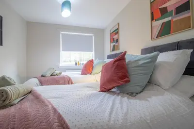 a bedroom with two beds with pillows and a window at Hawick Apartment- 2-Bed in Coatbridge, Mins from Motorway to Glasgow in Old Monkland
