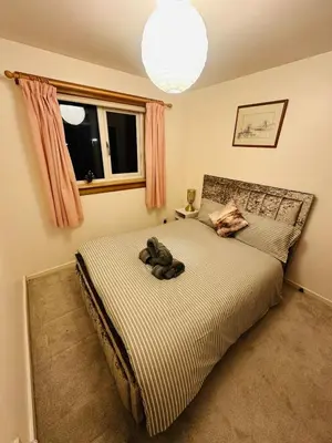 a bedroom with a bed with a stuffed animal on it at Modern & Cosy 3 Bedroom Inverkeithing home- Ideal for Edinburgh Dunfermline & St Andrews with Free Parking in Inverkeithing