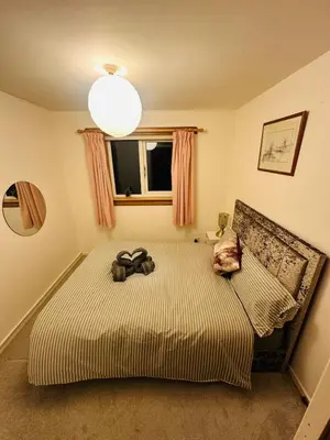 a bedroom with a bed with a bow on it at Modern & Cosy 3 Bedroom Inverkeithing home- Ideal for Edinburgh Dunfermline & St Andrews with Free Parking in Inverkeithing