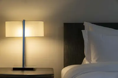 a lamp sitting on a table next to a bed at Paisley Road Courtyard in Glasgow